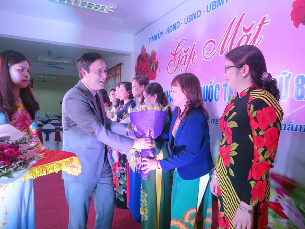 Chủ tịch UBND tỉnh Bùi Minh Châu tặng hoa và quà cho các cán bộ nữ.